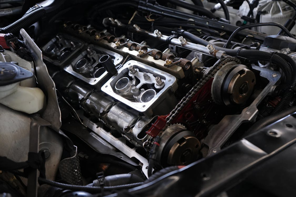 Close-up view of a disassembled car engine showing the camshaft, timing chain, and cylinder head components during repair or maintenance.
